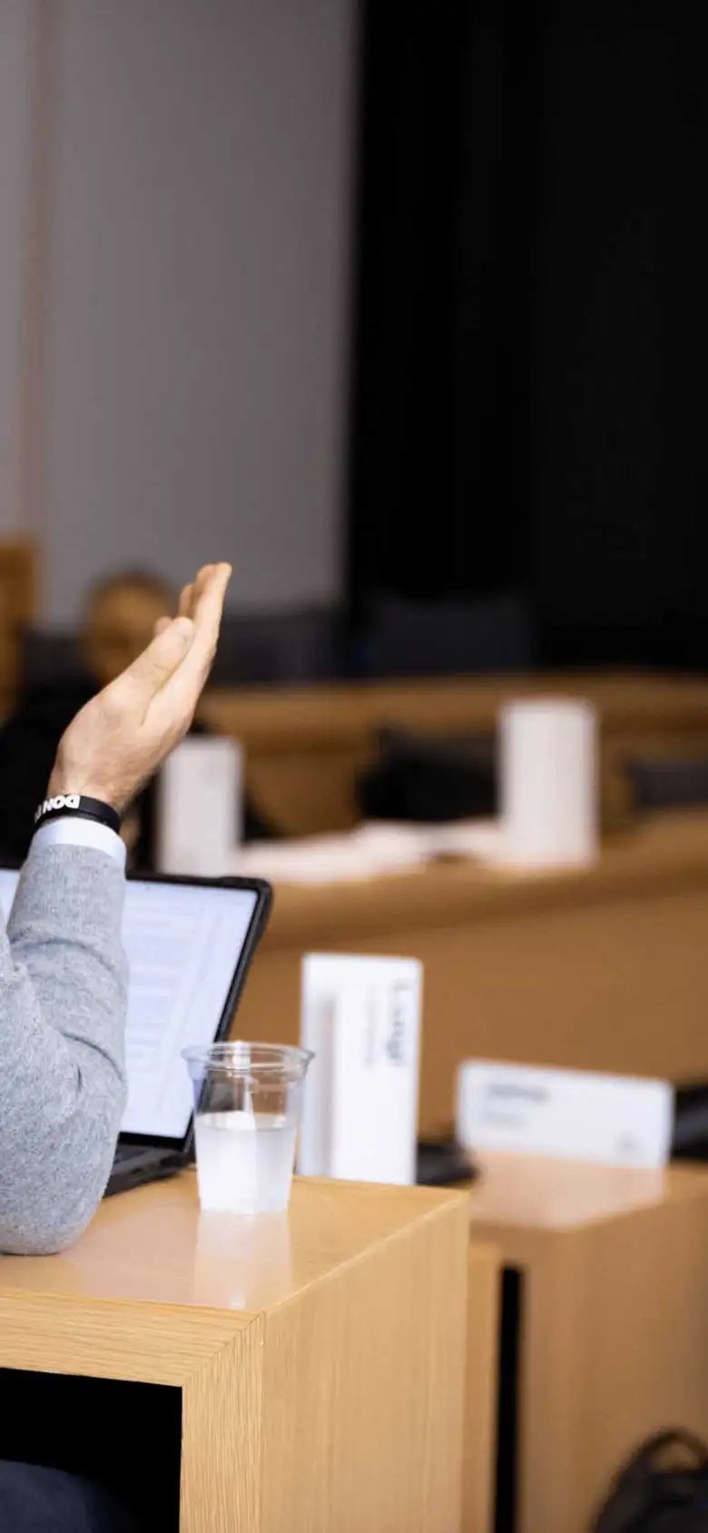 A student talks to a lecturer from their seat.