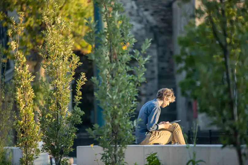 A student sitting and reading on university campus