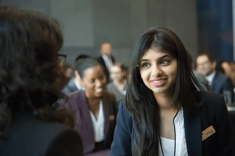 A smiling woman in conversation with another woman