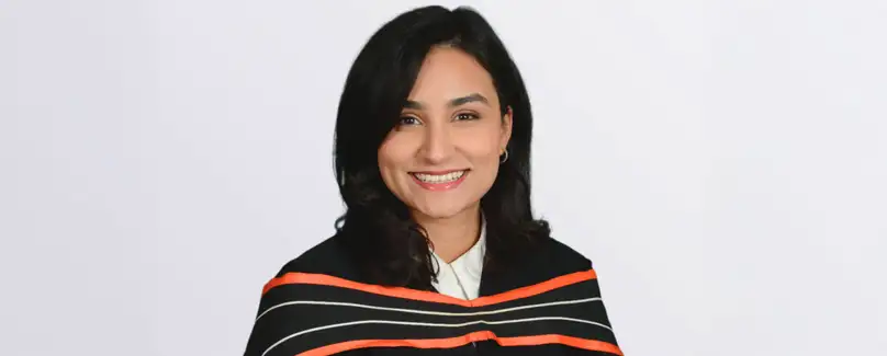 A smiling woman in a graduation gown