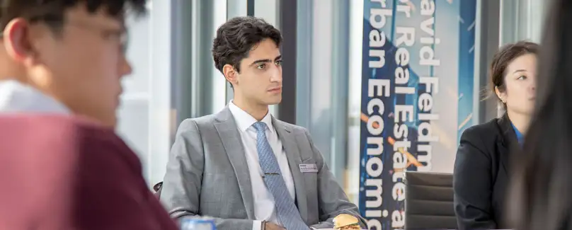 A student sits at a board room table concentrating